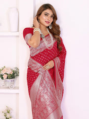 Woman wearing a red saree with white patterns against a white background