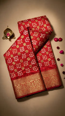 Red saree with gold patterns on a beige background