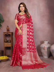 Woman wearing a red saree with white patterns in a decorative setting.
