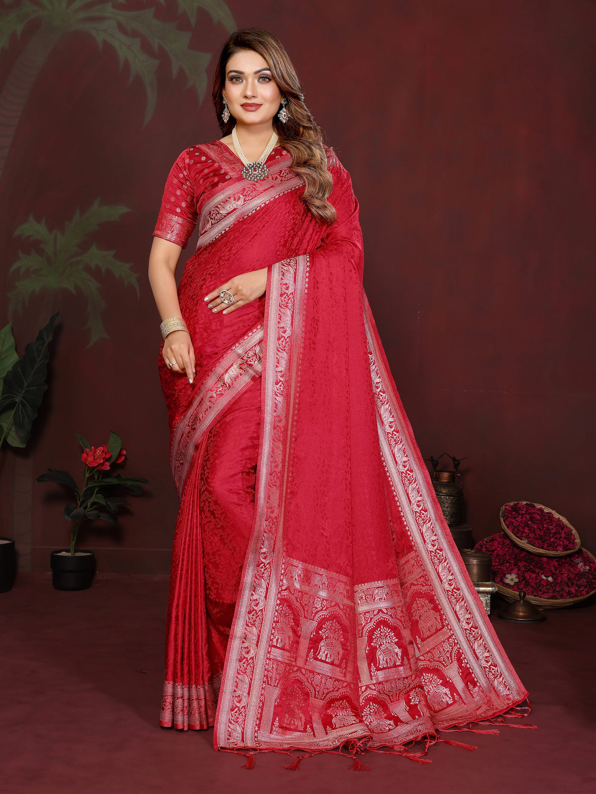 Woman wearing a red saree with white patterns against a dark background