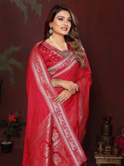 Woman in a red saree with white patterns against a dark background