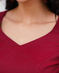 Close-up of a person wearing a red garment with a V-neckline.