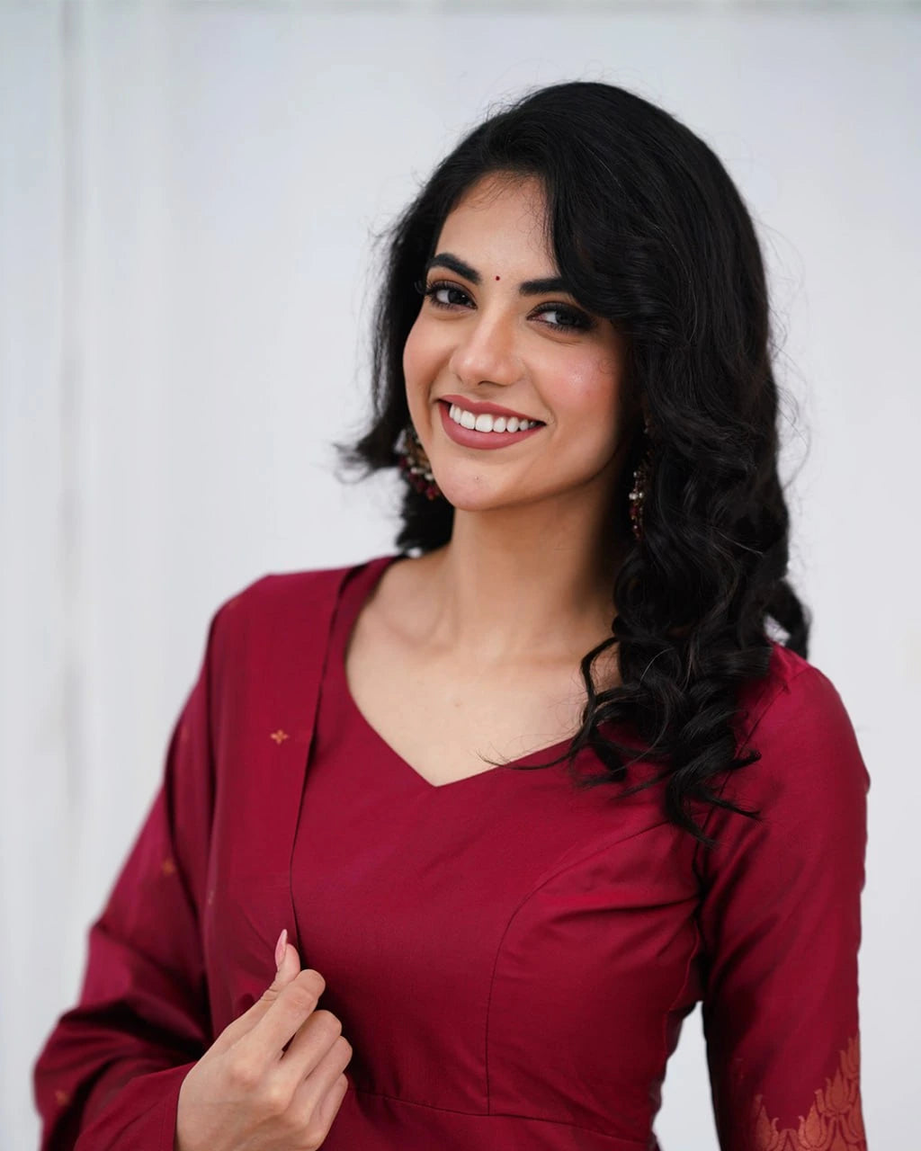 Woman wearing a red traditional outfit with a plain background