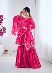 Woman wearing a bright pink traditional outfit with a matching dupatta against a white background