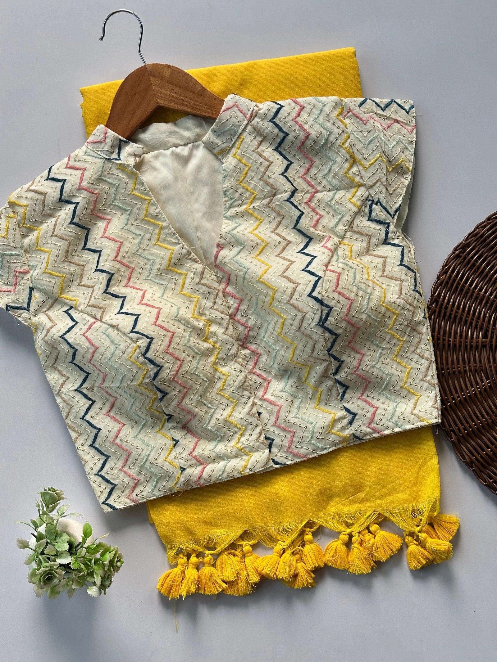 Textile with zigzag pattern and yellow tassels on a gray background