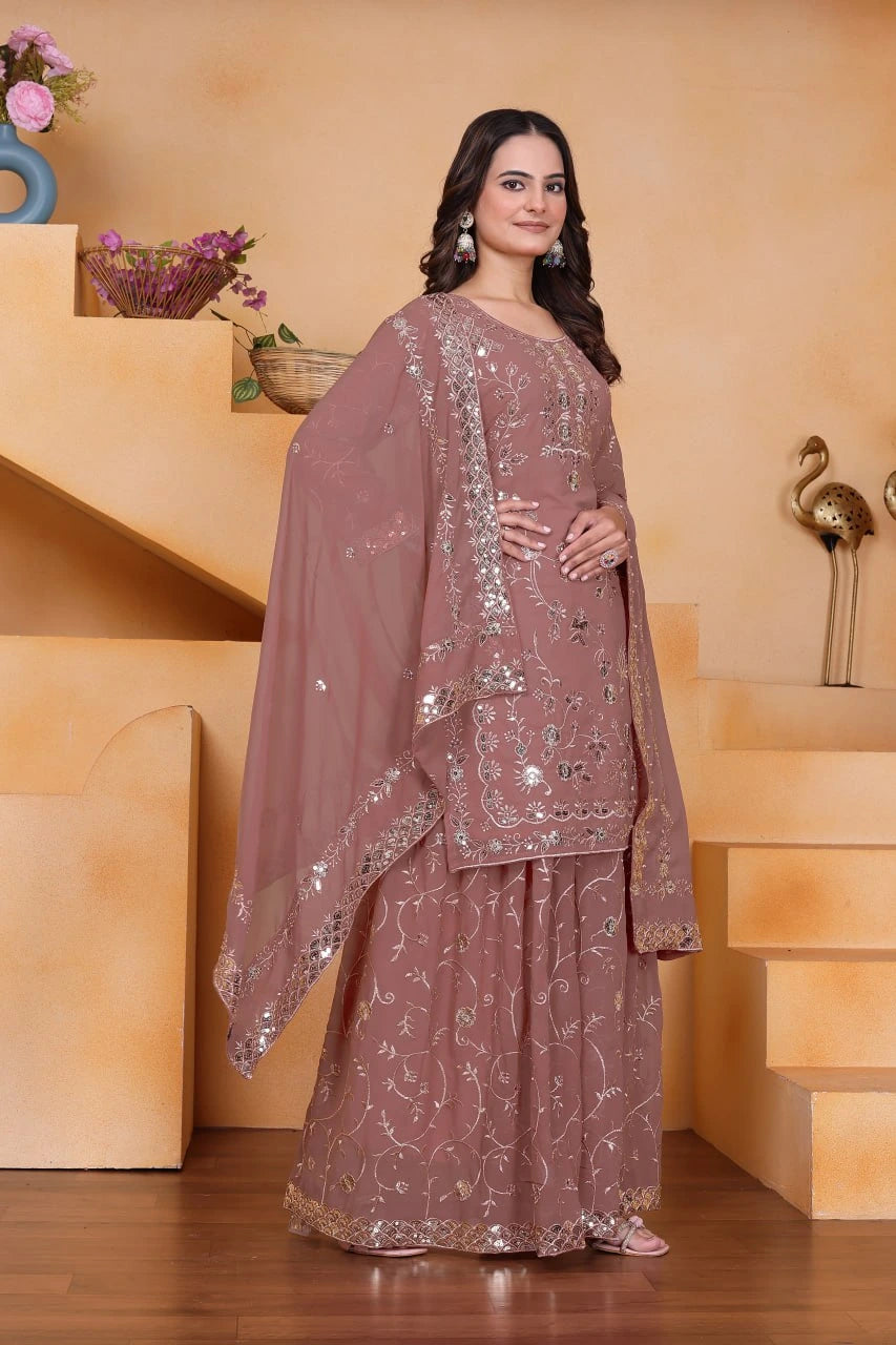 Woman in a traditional outfit standing in a decorative indoor setting.