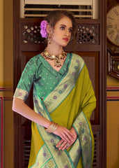 Woman wearing a green and yellow saree with jewelry in an indoor setting