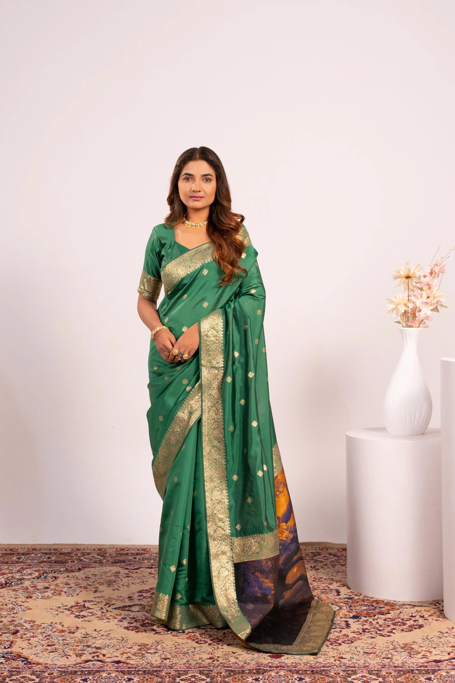 Woman wearing a green saree with gold border on a white background