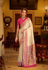 Woman in a traditional saree standing in an ornate room with decorative elements.