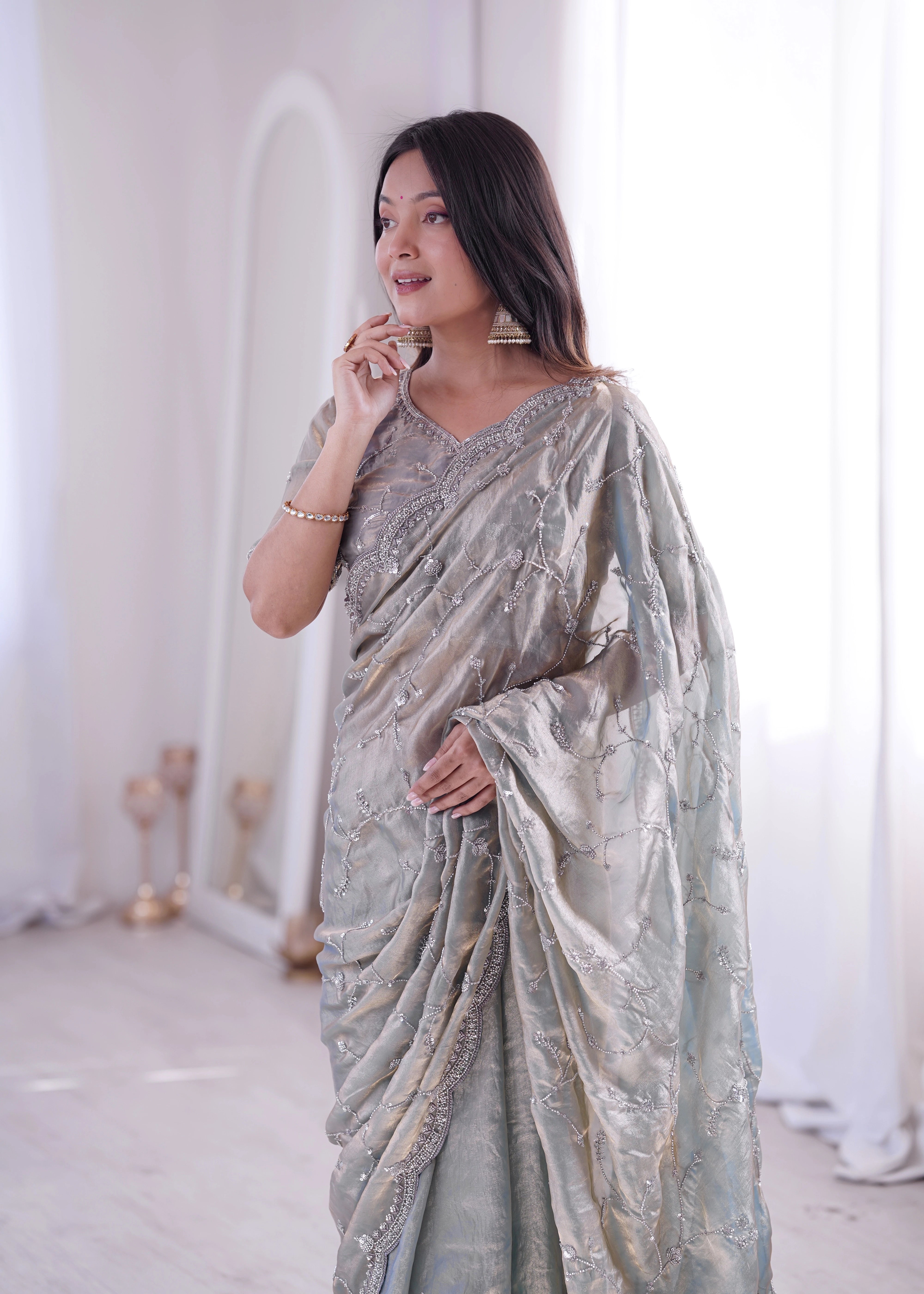 Woman wearing a light blue saree with a white background