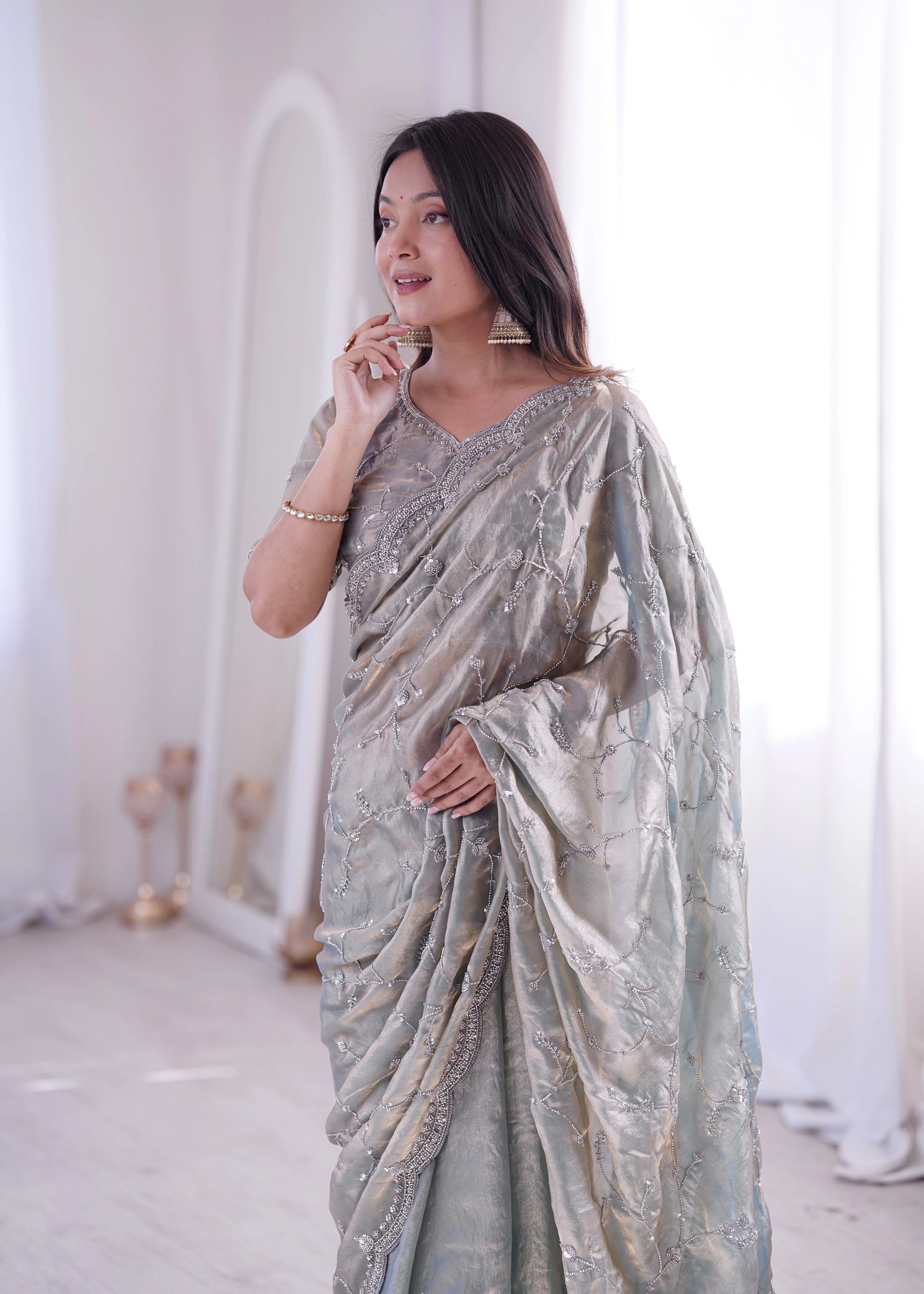 Woman wearing a light blue saree with a white background