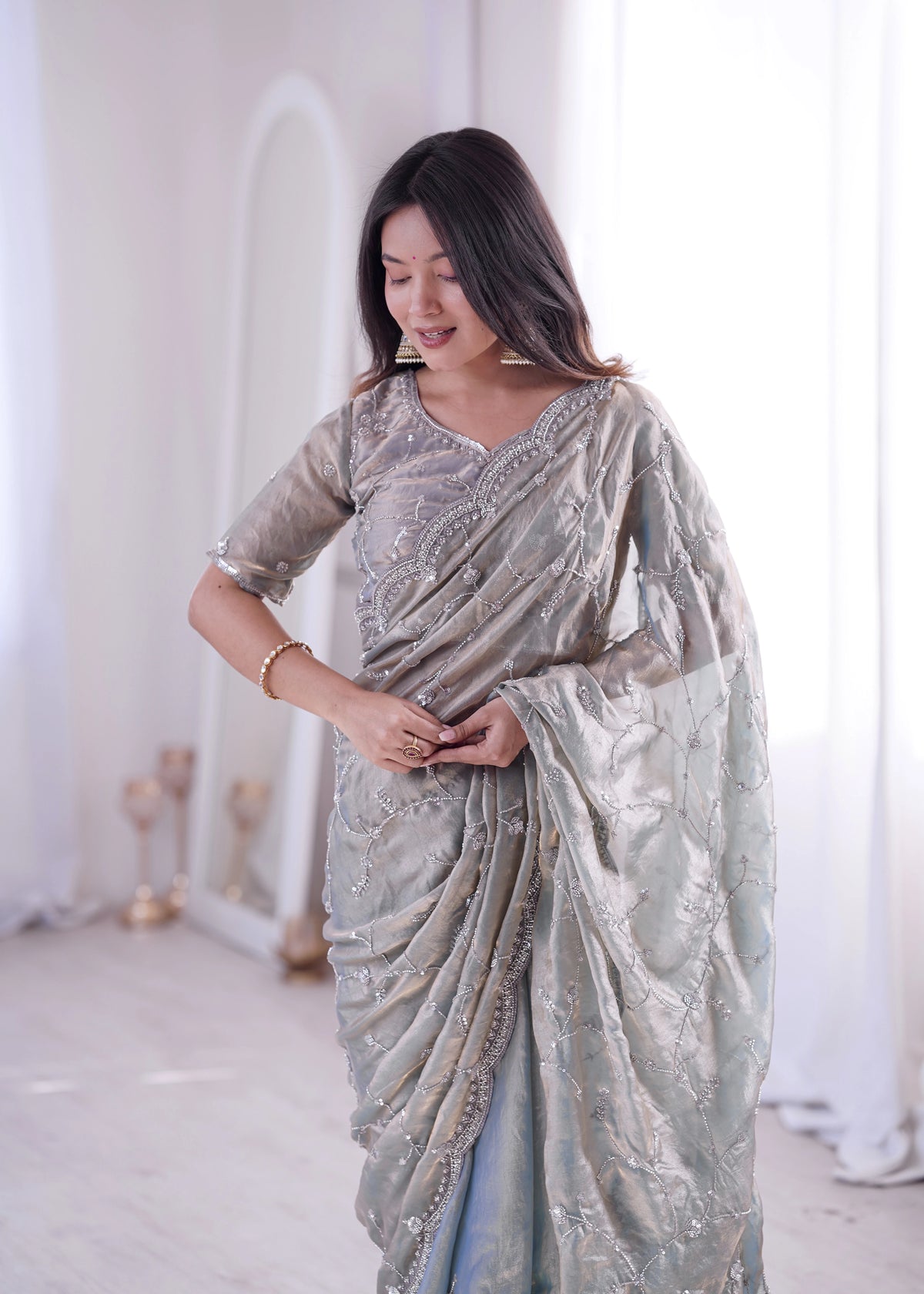 Woman wearing a light blue saree with a white background