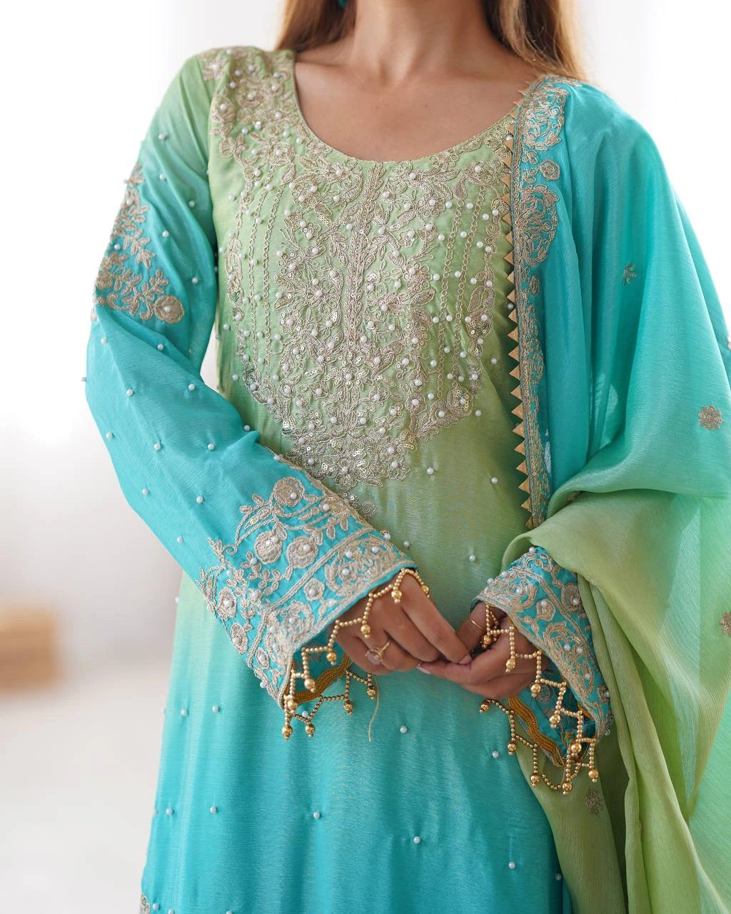 Light green and turquoise traditional outfit with intricate embroidery.