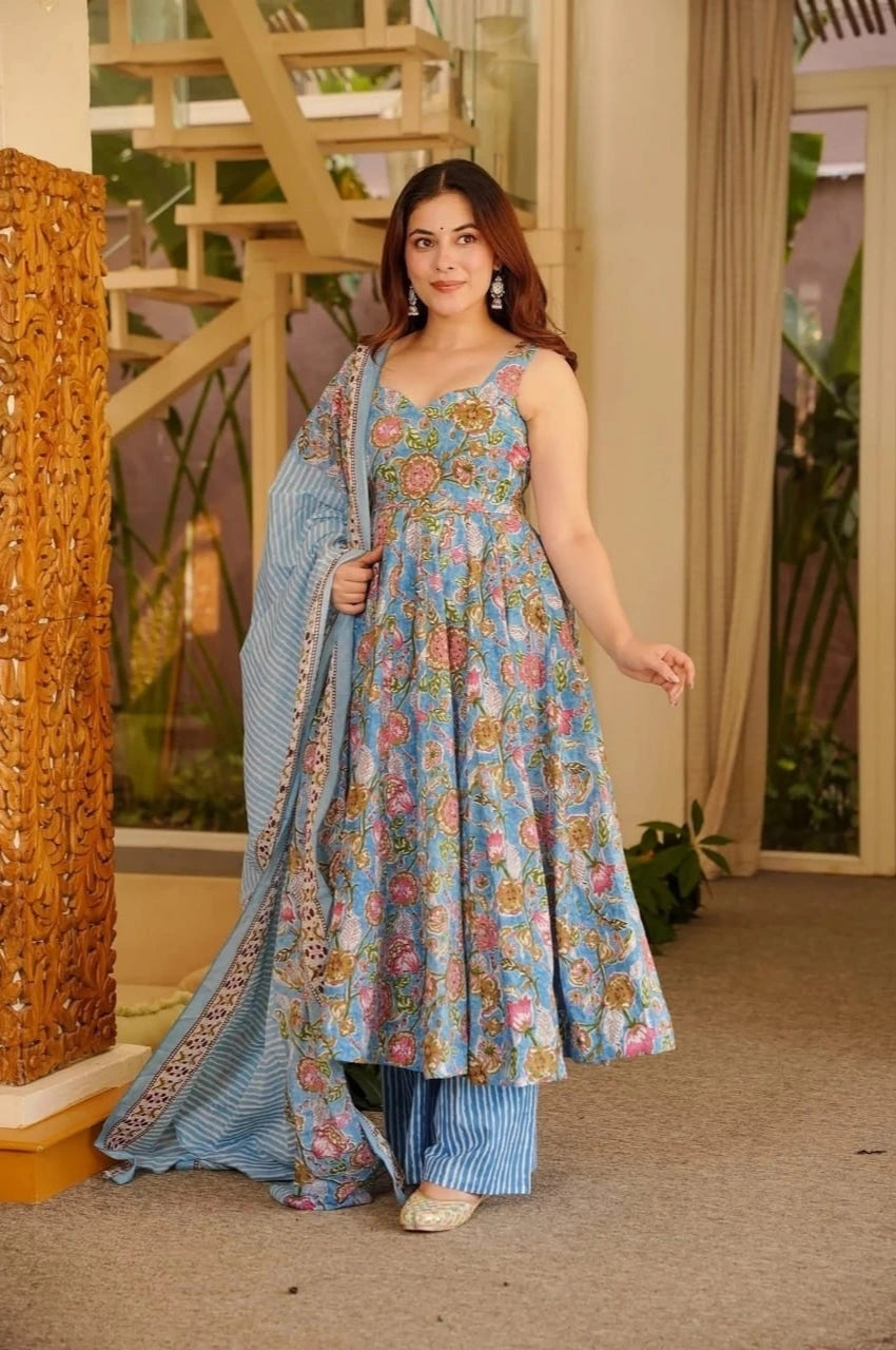 Woman in a floral dress standing indoors with decorative elements in the background