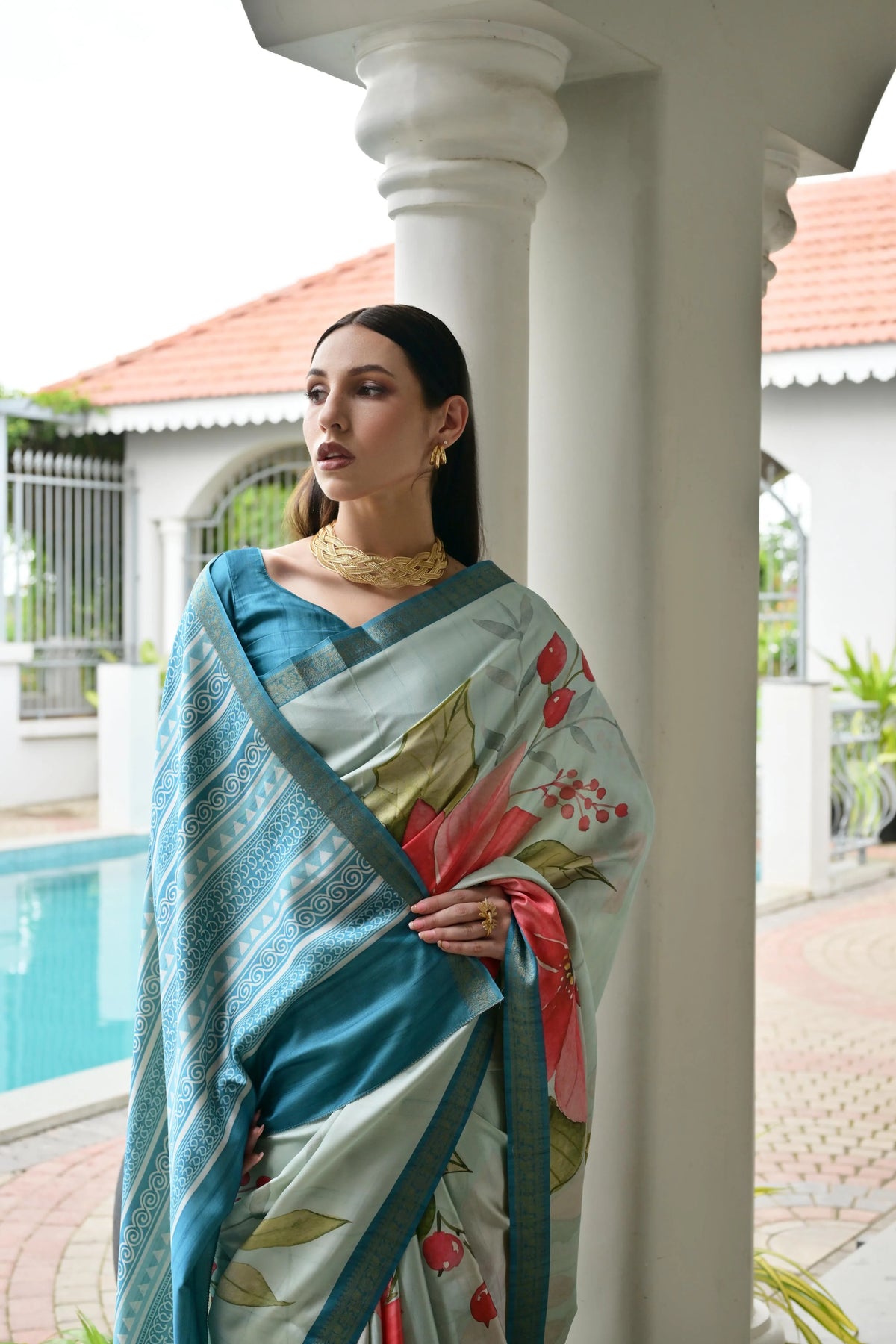 Woman wearing a floral saree by a poolside