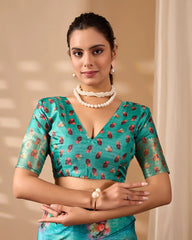 Woman wearing a turquoise blouse with floral patterns against a beige background