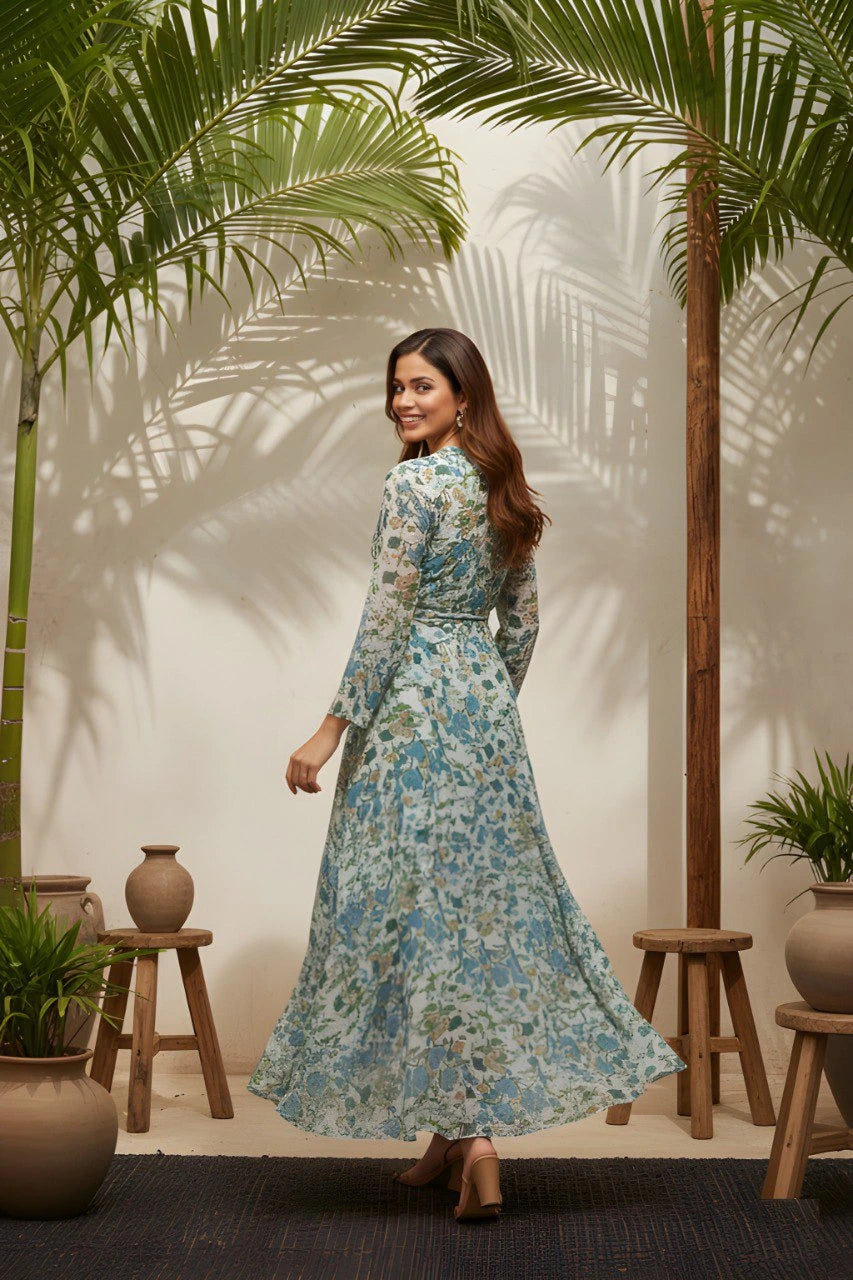 Woman in a floral dress standing in a room with palm trees and plants.