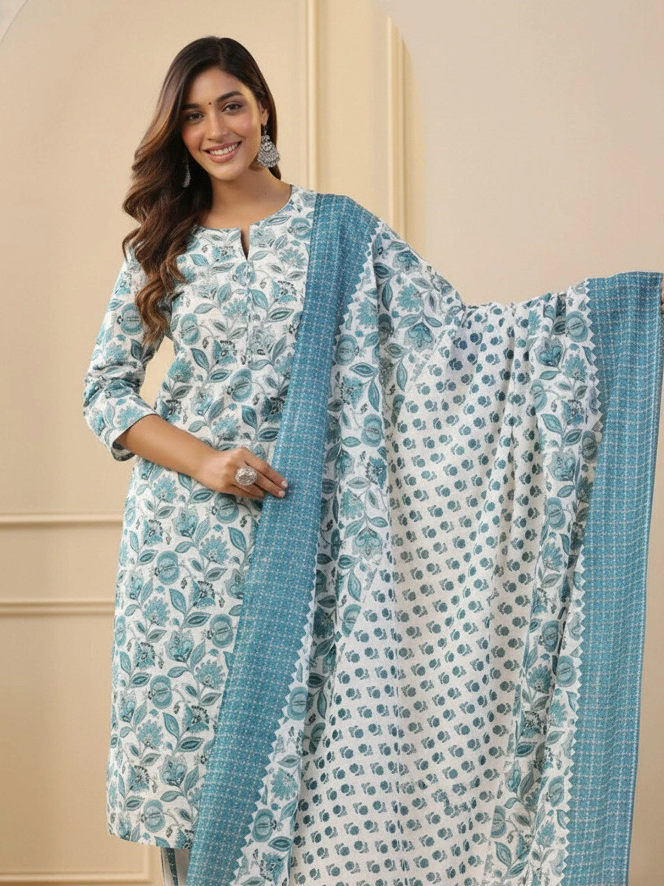 Woman wearing a blue and white floral dress with a matching dupatta against a beige background