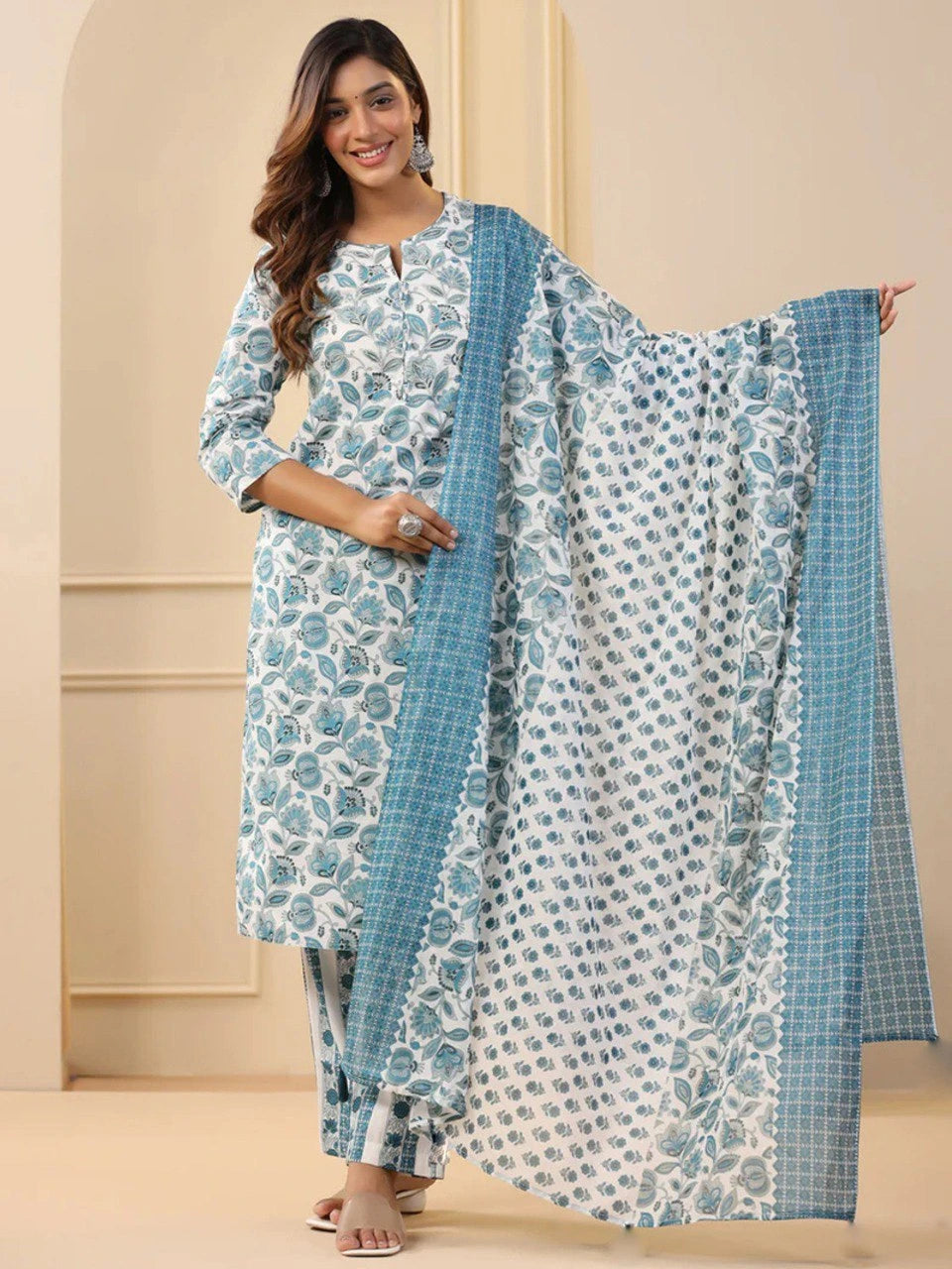 Woman wearing a blue and white floral outfit with a matching dupatta.