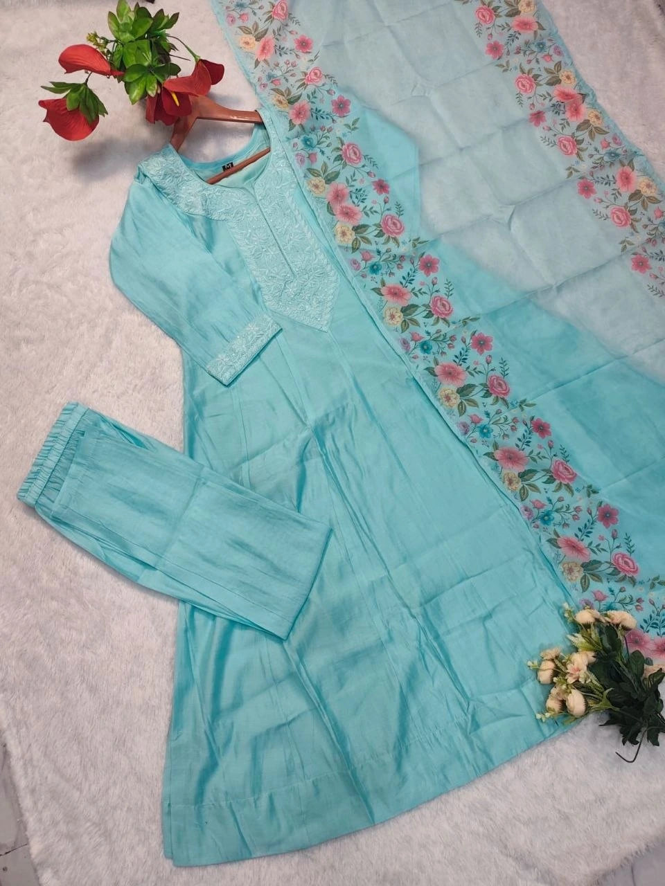 Light blue outfit with floral embroidery on a white background
