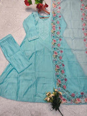 Light blue traditional outfit with floral embroidery on a textured surface