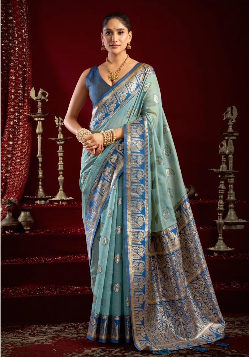 Woman wearing a light blue saree with a red background