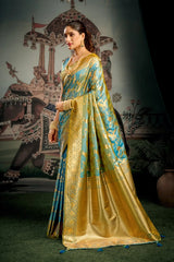 Woman in a traditional gold and blue saree standing in front of an ornate backdrop.