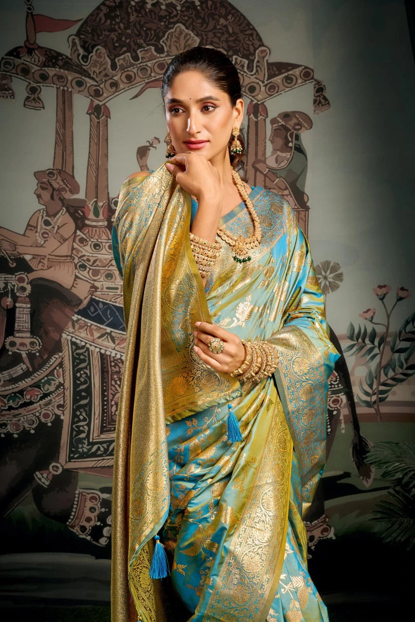 Woman in a traditional blue and gold saree with jewelry against an ornate wall.