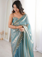 Woman wearing a light blue saree with a white background