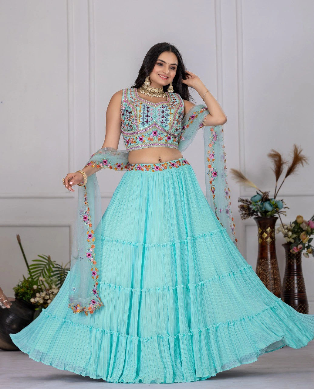 Woman in a light blue traditional outfit with floral details on a white background