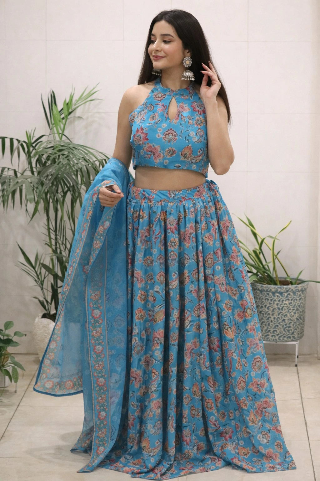 Woman wearing a blue floral traditional outfit with plants in the background