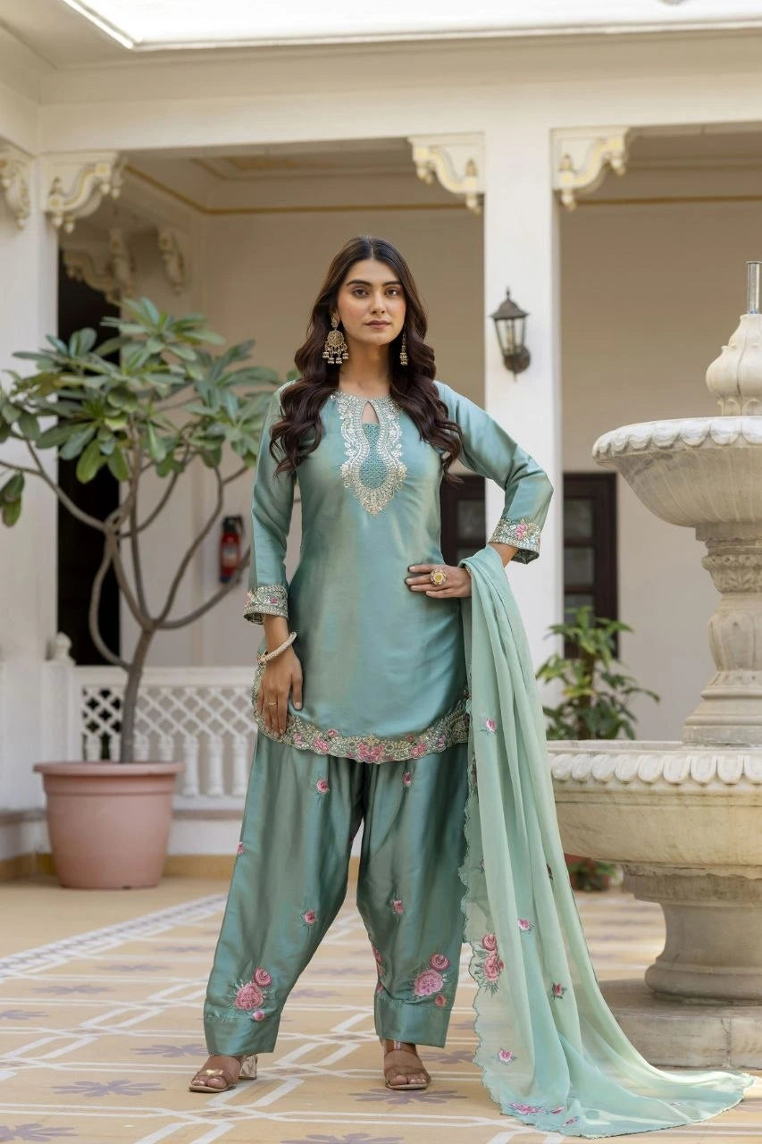 Woman in a traditional outfit standing in an outdoor setting with decorative elements.