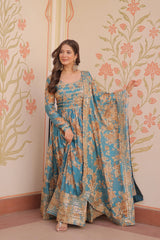 Woman in a floral dress standing against a decorative wall with floral patterns.