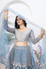 Woman in traditional blue and gray outfit with floral background