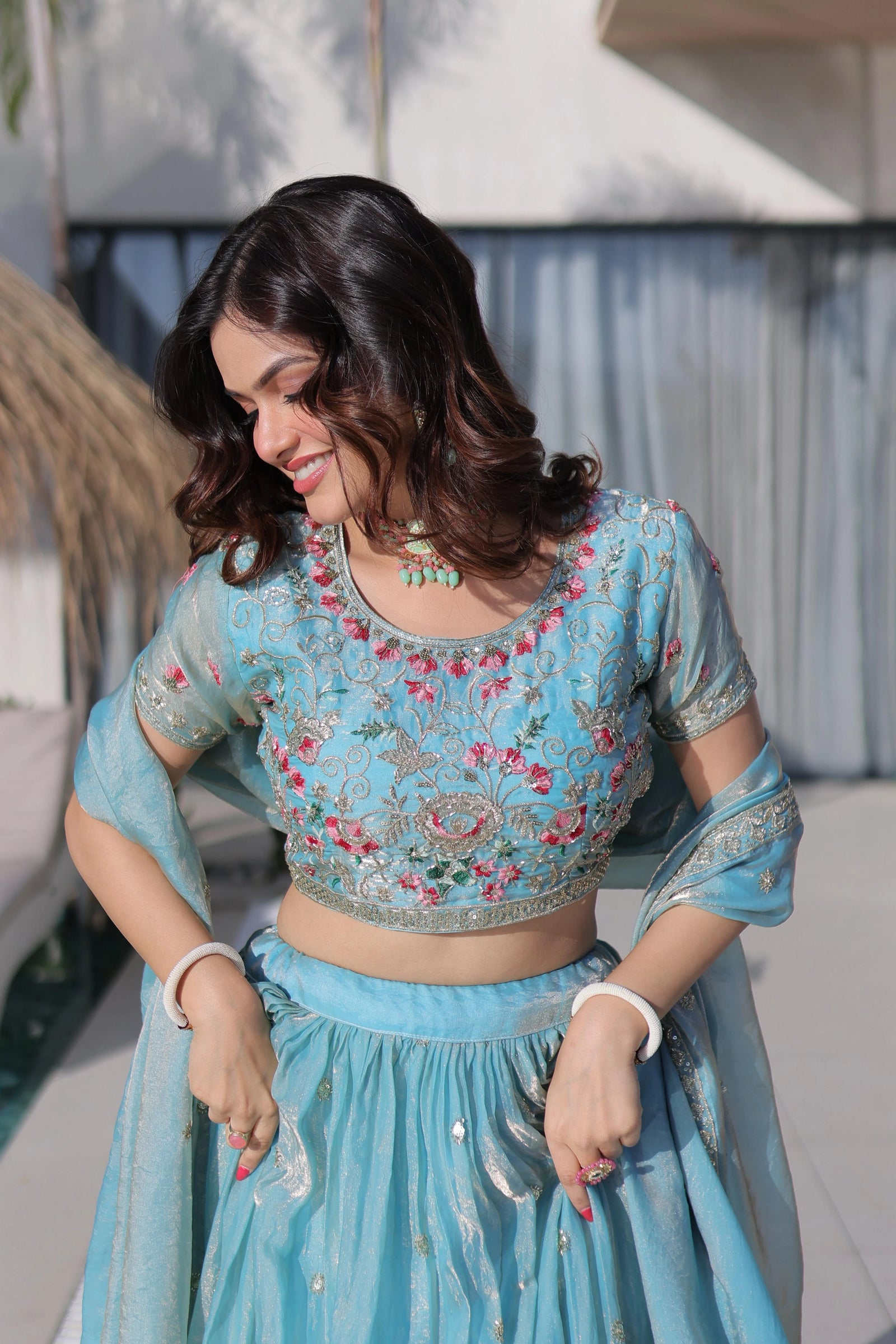 Woman wearing a traditional blue embroidered outfit with a blurred background