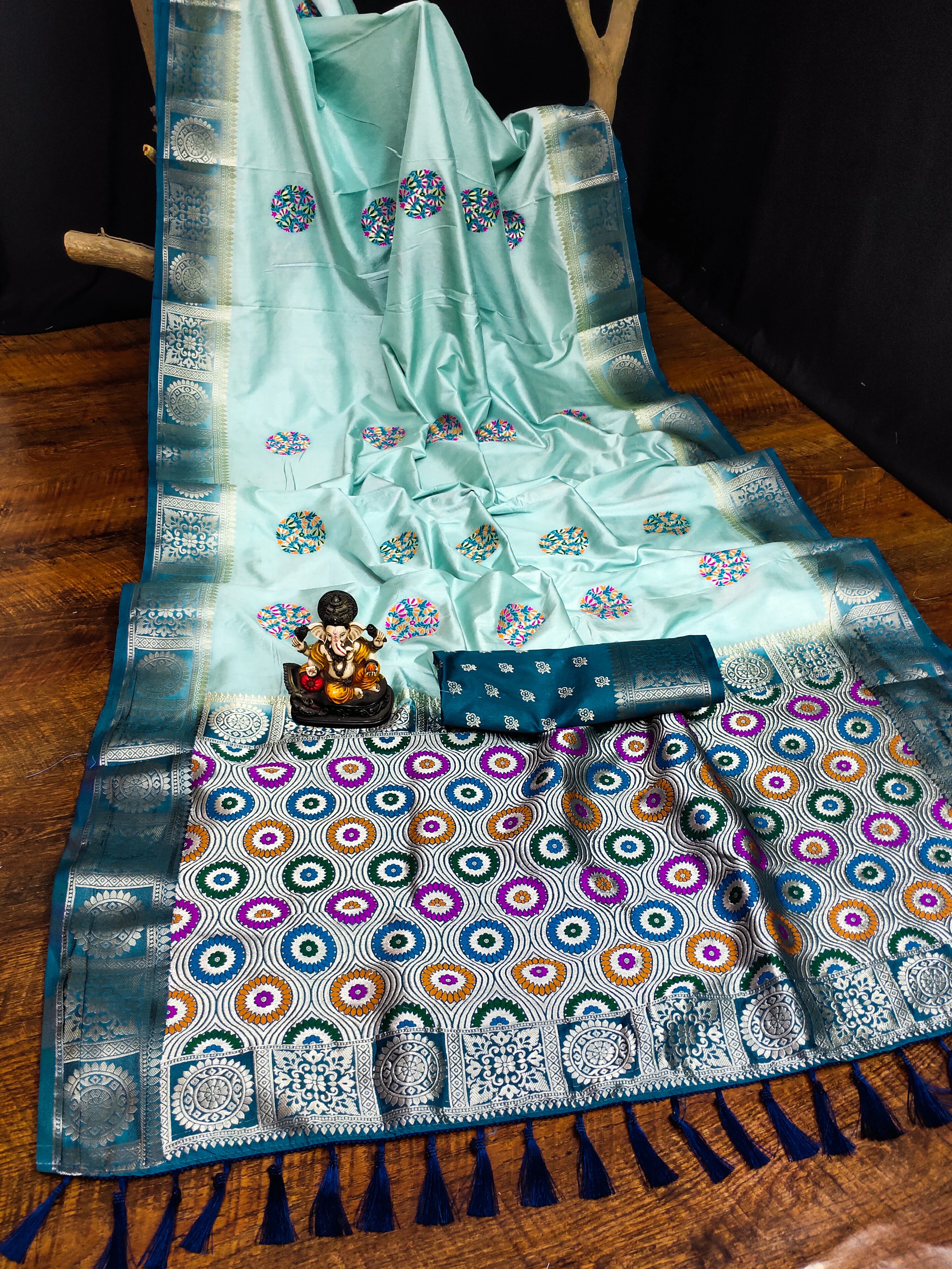 Light blue saree with colorful patterns on a wooden surface