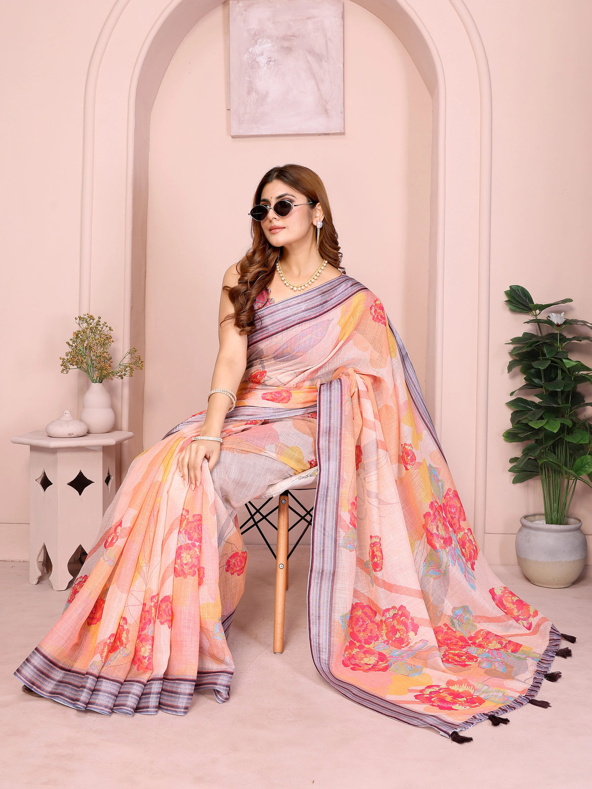 Soft Peach Linen Cotton Saree with Digital Floral Print draped in seated pose showing pallu and border detail