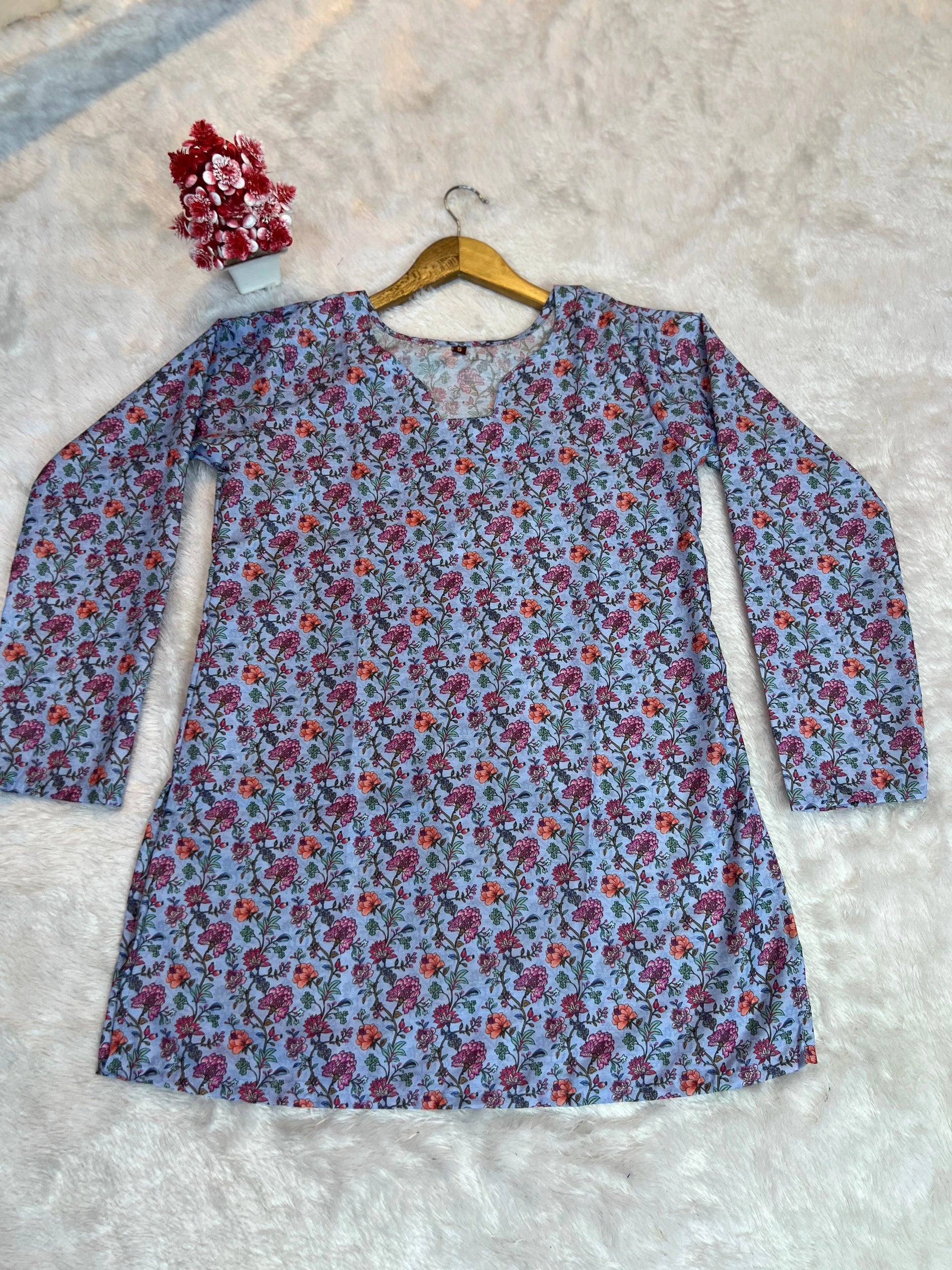 Floral-patterned shirt on a hanger against a textured surface