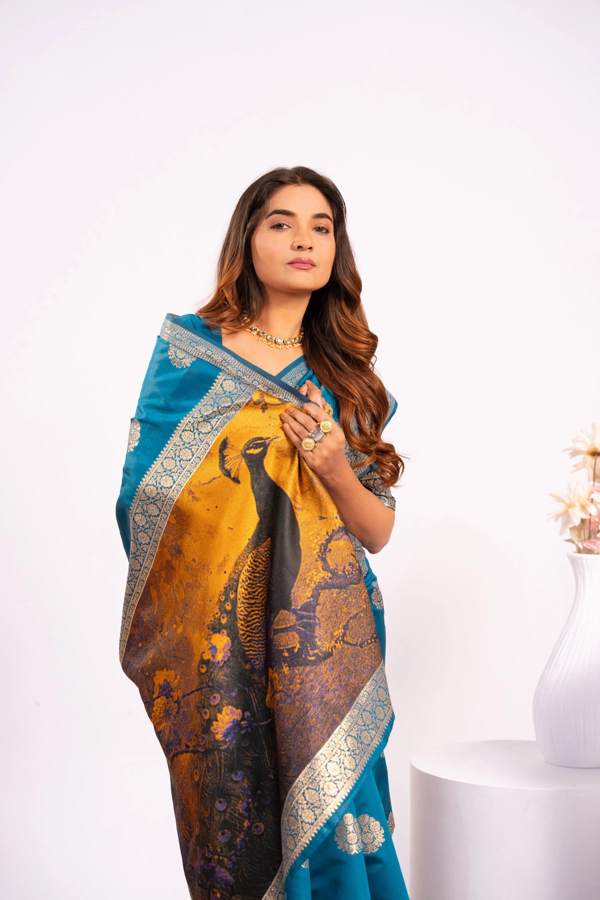 Woman wearing a blue and yellow saree with elephant design on a white background