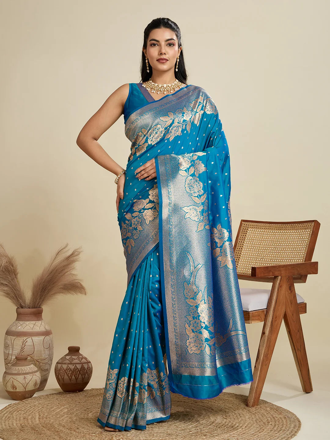 Woman wearing a blue saree with a floral pattern in a minimalistic setting