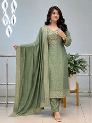 Woman wearing a green traditional outfit with a matching dupatta in an indoor setting.