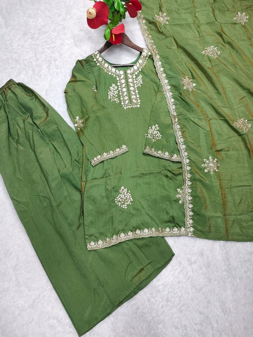 Green traditional outfit with white embroidery on a white background