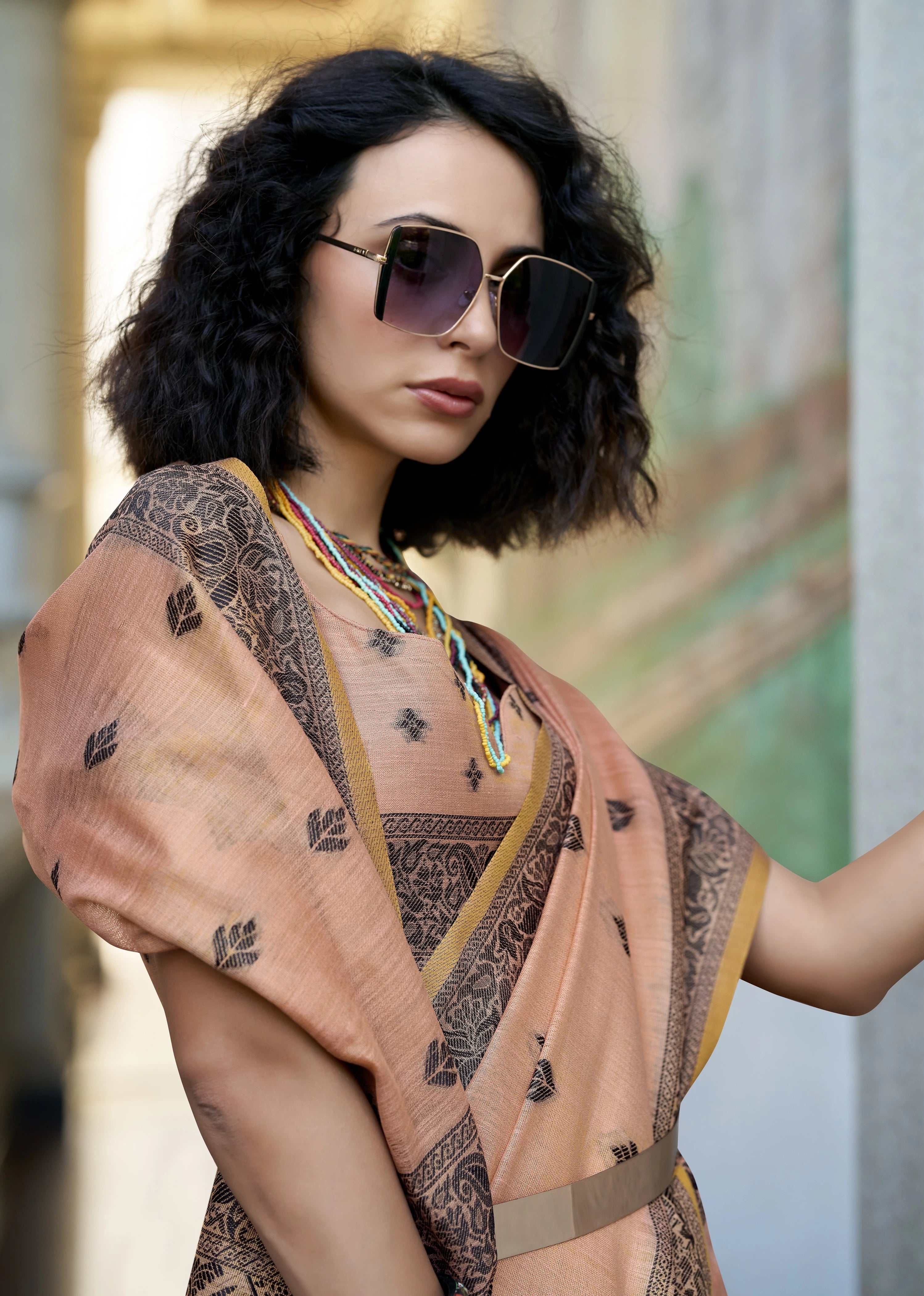 Woman wearing a patterned dress and sunglasses with a blurred background