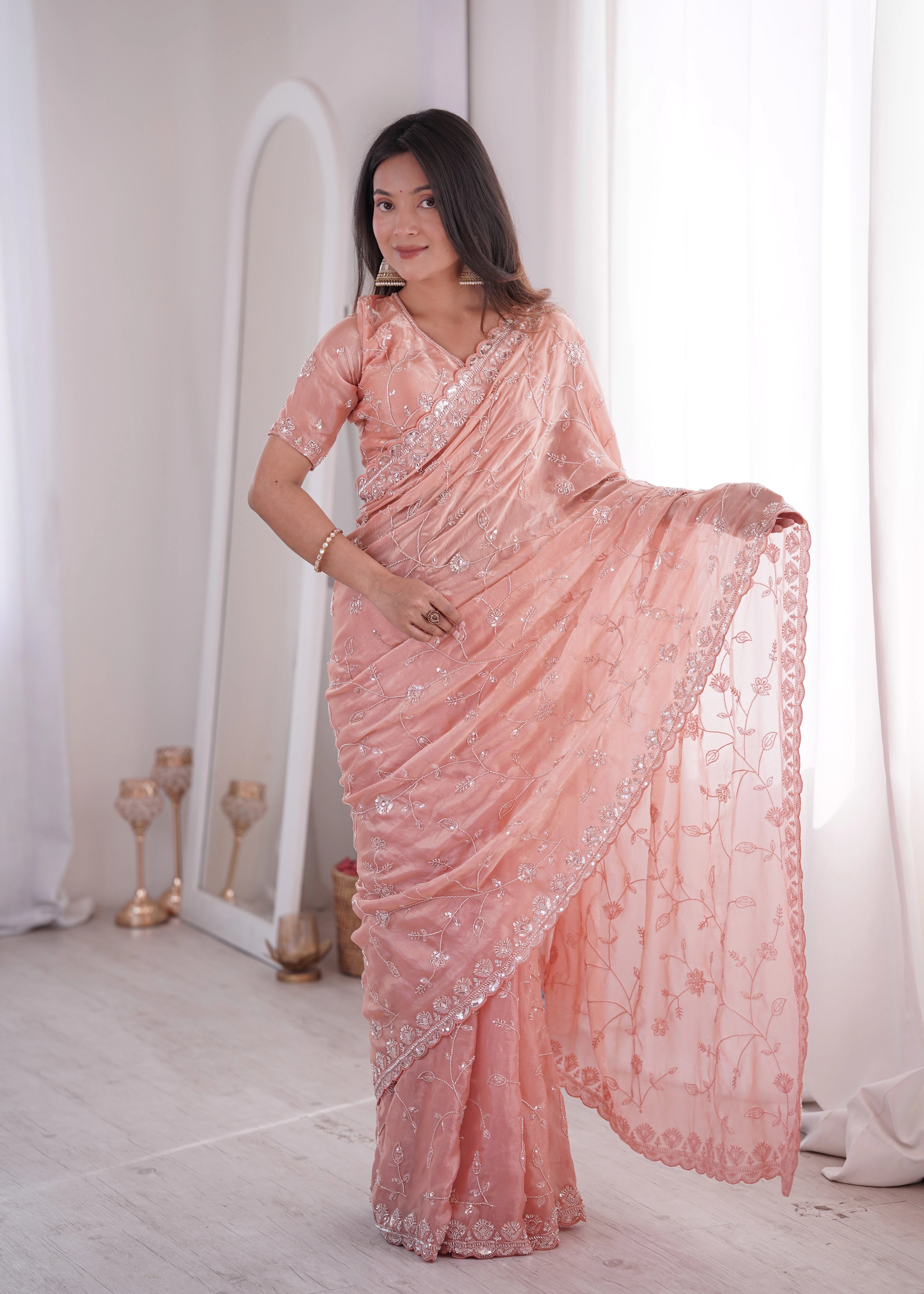 Woman wearing a pink saree with a white background