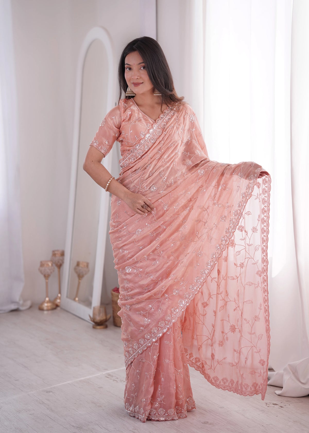 Woman wearing a pink saree with a white background