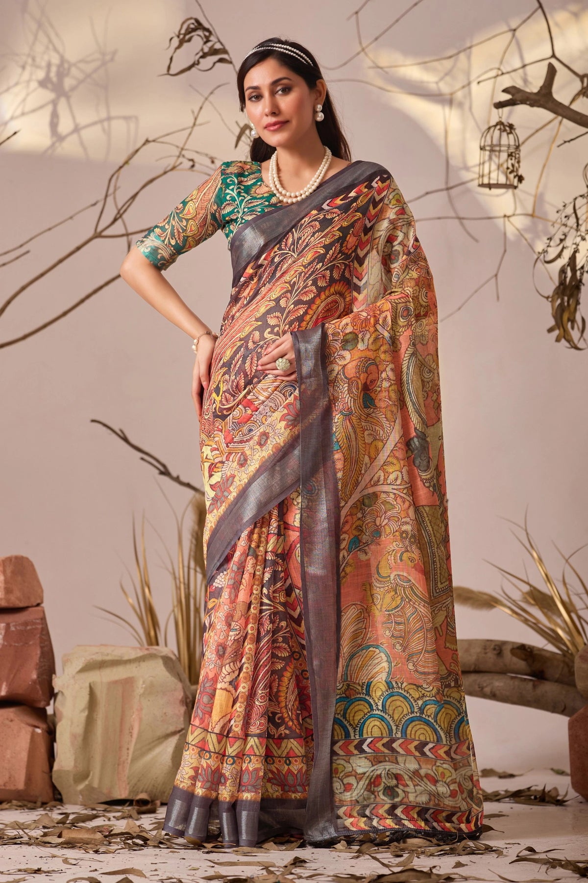 Woman wearing a traditional saree with a patterned design against a neutral background