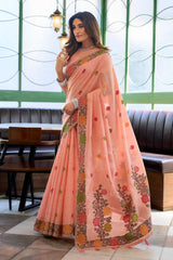 Woman wearing a peach saree with floral patterns indoors.