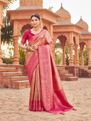 Woman in a traditional pink saree standing in front of an architectural structure.