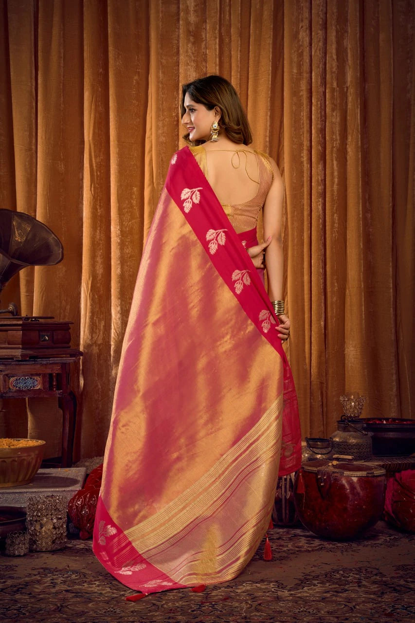 Woman wearing a pink and gold saree in a warm-toned room.