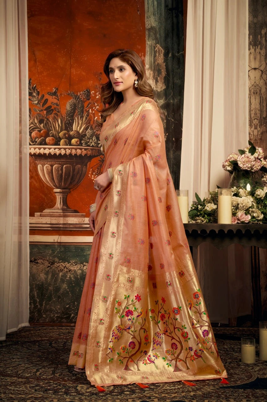 Woman in a traditional saree with floral patterns in a decorated room.